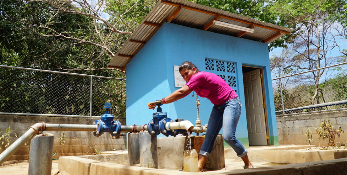 Mujer abriendo grifo de sistema de agua