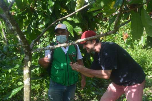Dos hombres haciendo fotos con sus móviles a el cacao de Nariño